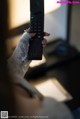 A woman in a white dress holding a remote control.