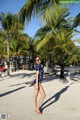 A woman in a polka dot swimsuit standing on a beach.