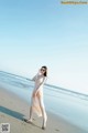 A woman standing on a beach next to the ocean.