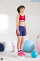 A young girl standing on a balance board in a living room.