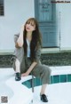 A woman sitting on the edge of a swimming pool.